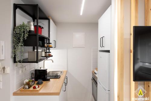 a kitchen with white walls and a wooden counter top at roomaki - new & stylish studio in the center with parking in Chalkida
