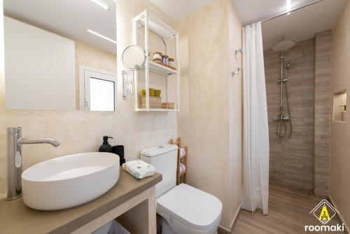 a bathroom with a sink and a toilet and a shower at roomaki - new & stylish studio in the center with parking in Chalkida