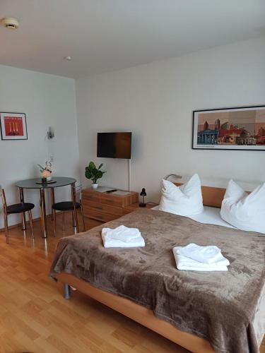 a bedroom with a bed and a table and a television at Business Apartment in Berlin