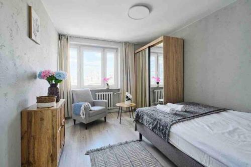 een slaapkamer met een bed, een stoel en een raam bij Emilii Plater 55 Center 2 bedrooms Living room balcony in Warschau