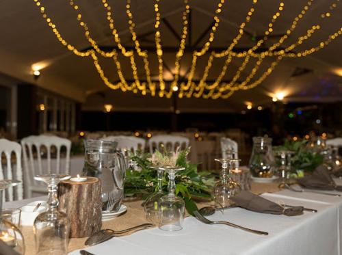 a table with a white table cloth and a chandelier at Rivland Resort in Païta