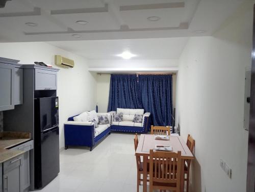 een woonkamer met een blauwe bank en een tafel bij Brand New 2 Bedroom Apartment Nemaa Bay in Sharm El Sheikh