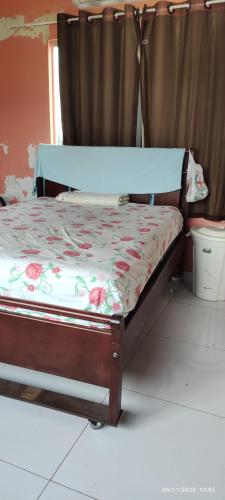a bedroom with a bed with a floral bedspread at Hostel Acre in Rio Branco