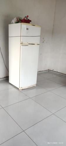 einen weißen Kühlschrank in einem Zimmer mit weißem Boden in der Unterkunft Hostel Acre in Rio Branco