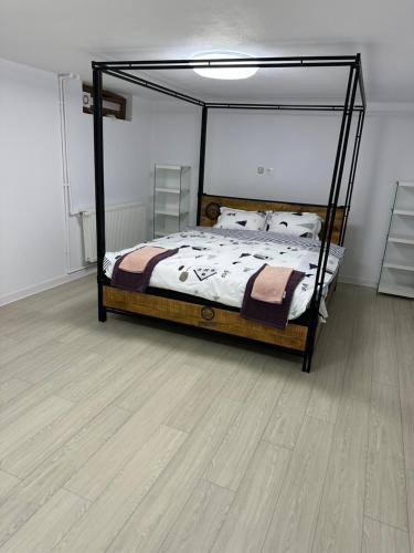 a bedroom with a bed and a wooden floor at Airport Confort House in Otopeni