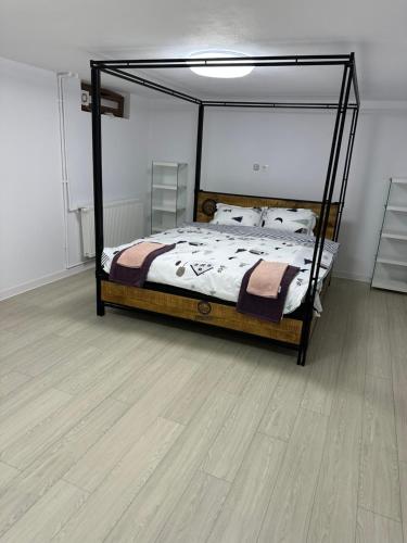 een slaapkamer met een bed en een houten vloer bij Airport Confort House in Otopeni