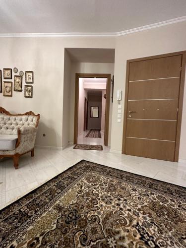 a living room with a door and a rug at Plex House in Tríkala