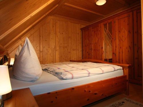 a bed in a wooden cabin with a white pillow at Am-Turm in Mellrichstadt