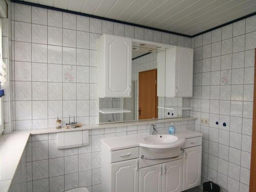 a white bathroom with a sink and a mirror at Am-Turm in Mellrichstadt