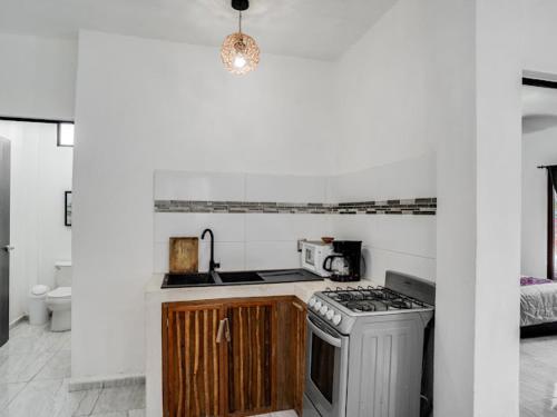 een keuken met een fornuis top oven naast een bed bij Casa Emma in Holbox Island