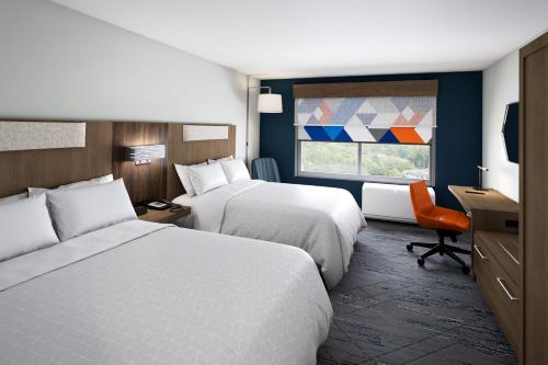 a hotel room with two beds and a window at Holiday Inn Express Holly Springs - Raleigh Area by IHG in Holly Springs