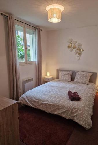 - une chambre dotée d'un lit avec une paire de chaussures dans l'établissement App 2 - T2 Lumineux et Jardin Hyper-Centre 5min de la gare, à Évreux