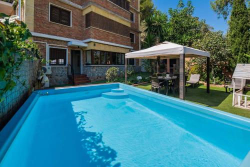 a large blue swimming pool in front of a house at XPCE Gibralfaro Gardens in Málaga