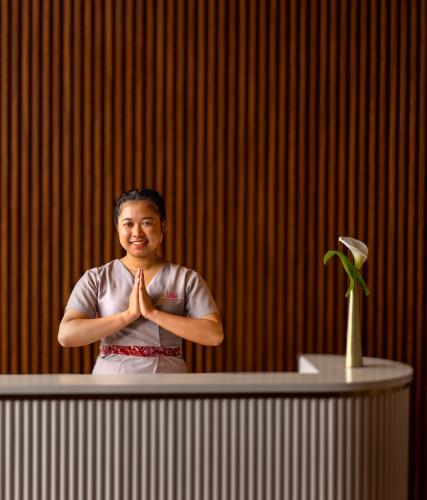 a woman sitting at a table with her hands in front of at The Golden Ridge Hotel in Nuwara Eliya