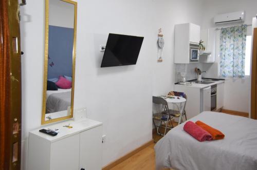 Habitación blanca pequeña con cama y espejo en LOFT PUERTA DE SOL, en Madrid