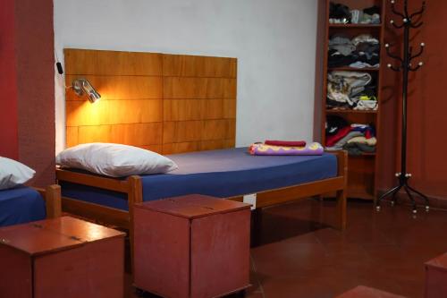 a bedroom with a bed with a wooden headboard at Nomada Hostel in Asuncion