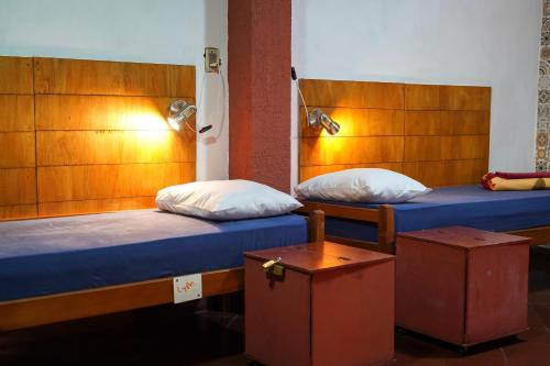 two twin beds in a room with two lamps at Nomada Hostel in Asuncion