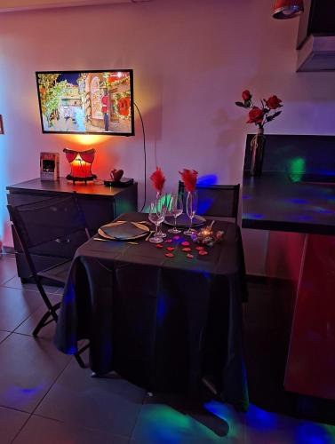 - une salle à manger avec une table noire et des fleurs dans l'établissement La Cage Village Naturiste, au Cap d'Agde