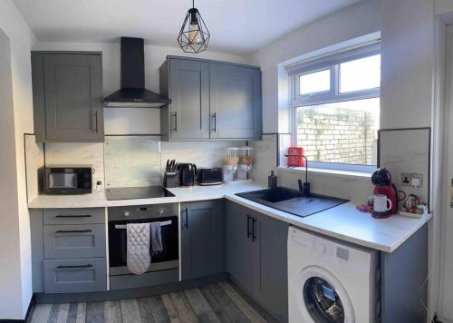 a kitchen with a sink and a washing machine at Modern and Comfy House, Sky sports, PS3 in Gateshead