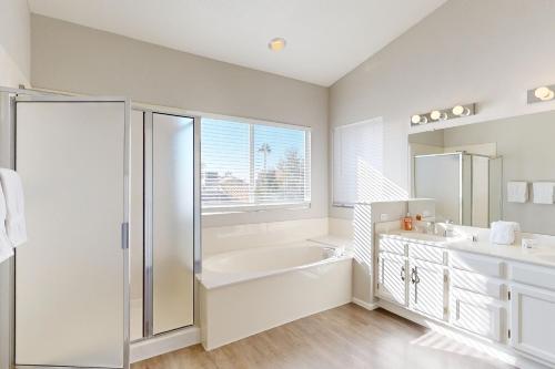 La salle de bains blanche est pourvue d'une baignoire et d'un lavabo. dans l'établissement Silverwood Getaway, à Phoenix