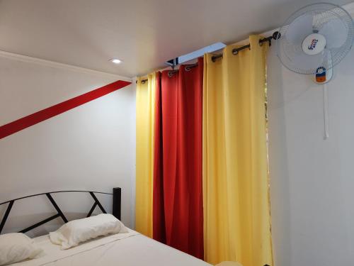 Schlafzimmer mit bunten Vorhängen und einem Bett in der Unterkunft Wally World Inn in Comayagua
