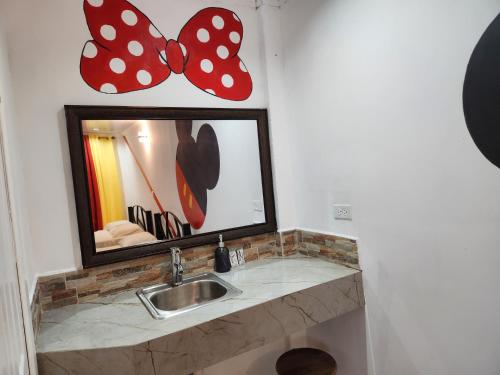 y baño con lavabo, espejo y mariposas. en Wally World Inn, en Comayagua