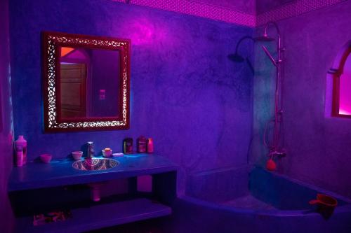 a purple bathroom with a sink and a mirror at Mask Off Artel in Essaouira
