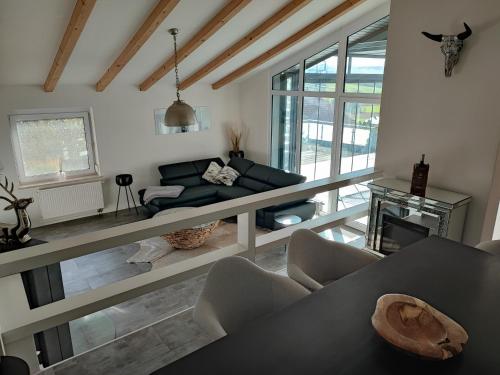 una sala de estar con un sofá y una mesa en Ferienhaus Alpenblick, en Ermengerst