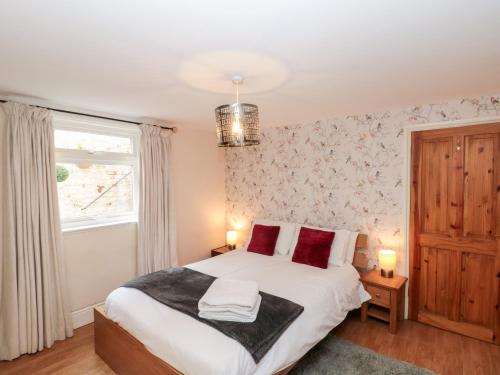 - une chambre avec un lit doté d'oreillers rouges et une fenêtre dans l'établissement 8A Wellington Terrace, à Whitby