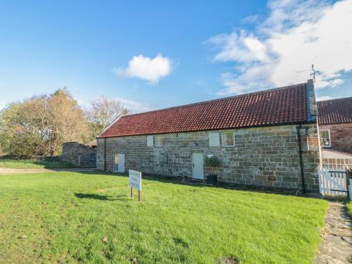 an old brick building with a sign in front of it at Owl Barn in Whitby