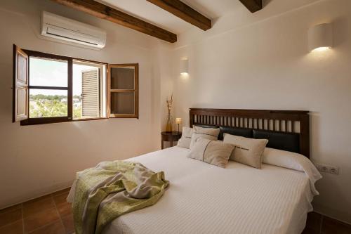 una camera da letto con un grande letto bianco e una finestra di CAN NOVES - Villa de 5 suites 31 y 9 a Sant Francesc Xavier