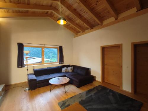 een woonkamer met een bank en een tafel bij Villa Mountainview in Bludenz