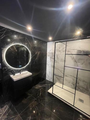 une salle de bain avec un lavabo et un miroir dans l'établissement La Suite Prestige Jacuzzi,Sauna,Netflix,Disney, à Amiens
