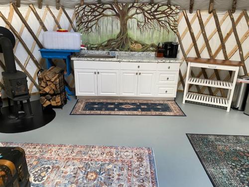 Habitación con 2 alfombras y cocina con fogones. en Sweet Retreat and Yurt Farm, en New Ipswich