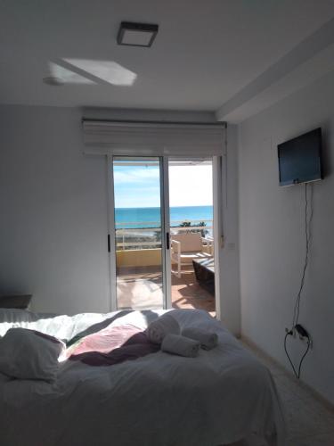 1 dormitorio con cama y vistas al océano en Atico Duplex 1ª, en Xilxes