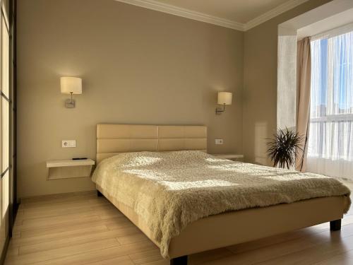 sypialnia z dużym łóżkiem i oknem w obiekcie Kalinova Sloboda Home w Iwano-Frankiwsku