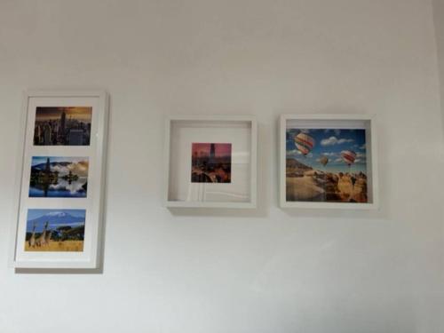 a group of four pictures on a white wall at [La Maison du Monde] in Rome