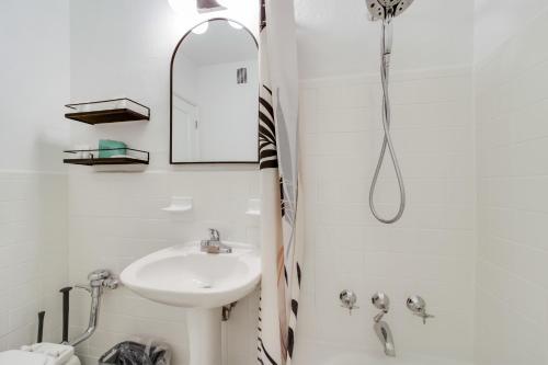 a white bathroom with a sink and a mirror at Tropics Hotel Miami Beach in Miami Beach