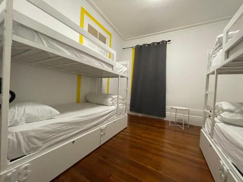 a bedroom with two bunk beds and a wooden floor at Owls Hostel in Porto