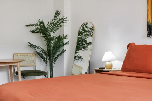 a bedroom with a bed and a plant in the corner at Tropics Hotel Miami Beach in Miami Beach