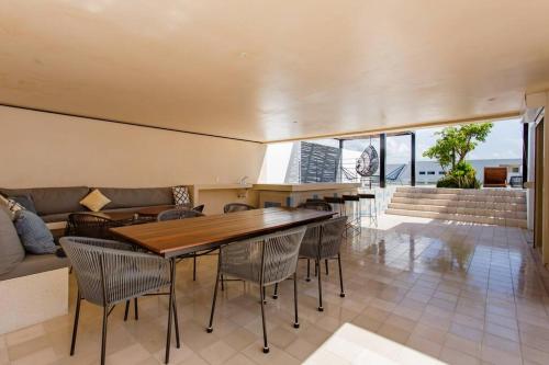 Riva Condos by The Spot Rentals في بلايا ديل كارمن: غرفة معيشة مع طاولة وكراسي وأريكة
