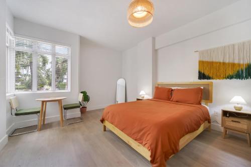 a bedroom with a bed and a table and a window at Tropics Hotel Miami Beach in Miami Beach