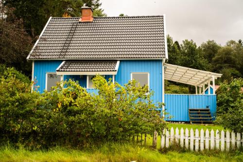 una casa blu con una recinzione bianca davanti di Landvetter Hotell a Härryda