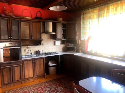 a kitchen with wooden cabinets and a table and a window at Prutets Guest House in Tatariv