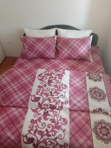 Lukavica的住宿－Stan na dan，一张带红白毯子和枕头的床
