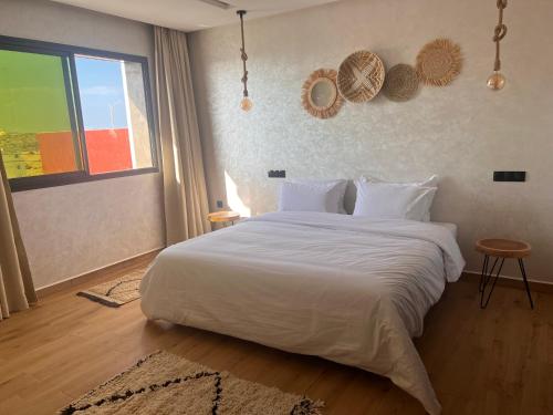 a bedroom with a large white bed and a window at Beach Side Imsouane in Imsouane