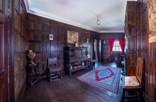 a living room with wood paneled walls and a stove at Lytham Hall Gate House in Lytham St Annes