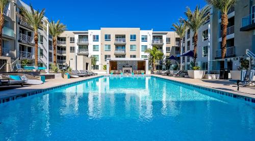 a large swimming pool with palm trees and buildings at Global Luxury Suites Irvine in Irvine