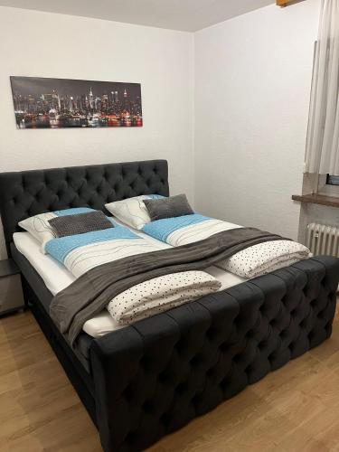 a large black bed in a room with a painting on the wall at Ferienhaus International 2 in Bad Harzburg