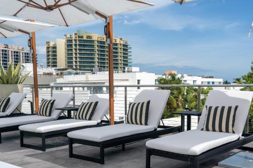 a row of chairs on a balcony with a view at Nassau Suite South Beach, an All Suite Hotel in Miami Beach